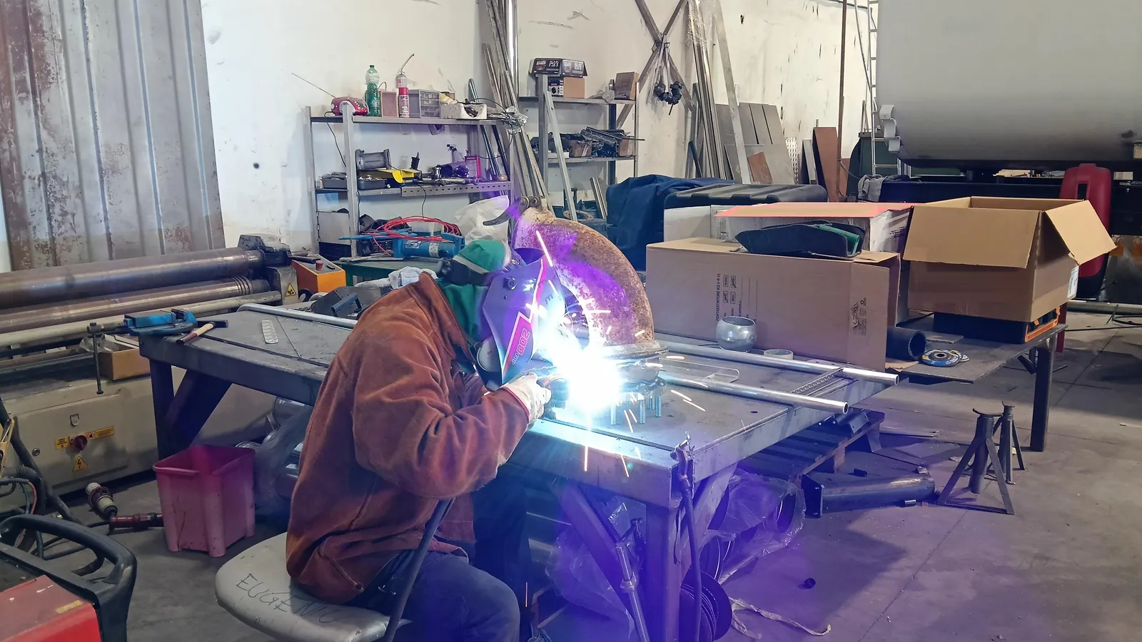 Operatore che salda un giunto metallico in officina.